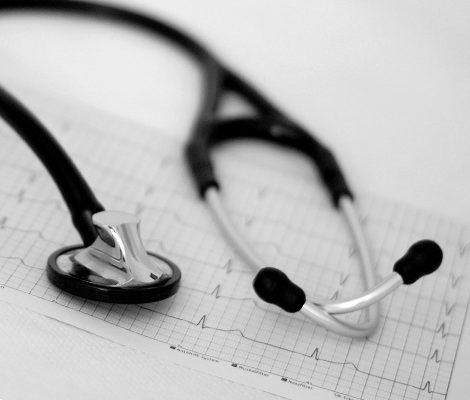 Ein Stethoskop liegt auf einem EKG-Ausdruck auf einem Schreibtisch