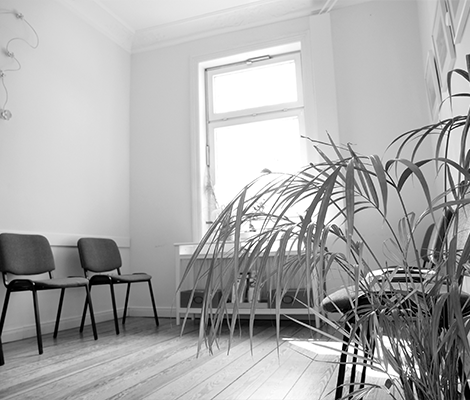 Wartebereich der Praxis mit hellen Wänden und bequemen Sitzmöglichkeiten